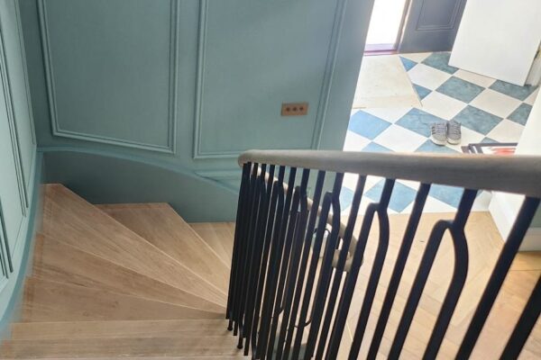 Curved oak staircase descending to a tiled entrance hall
