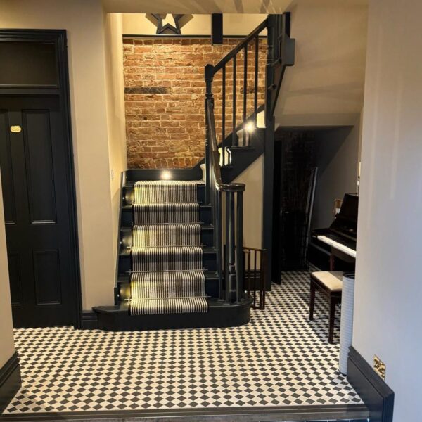 Painted staircase with stair runner in a period hallway