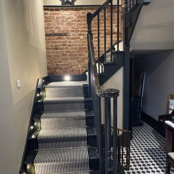 Painted staircase with stair runner in a period hallway