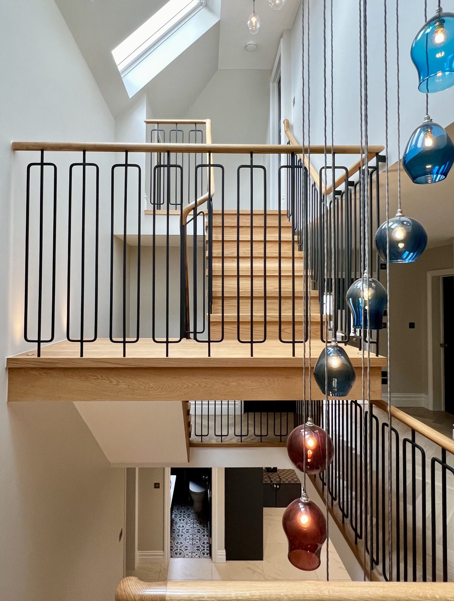 Oak treads and black balustrade over a herringbone floor, Summit Group project